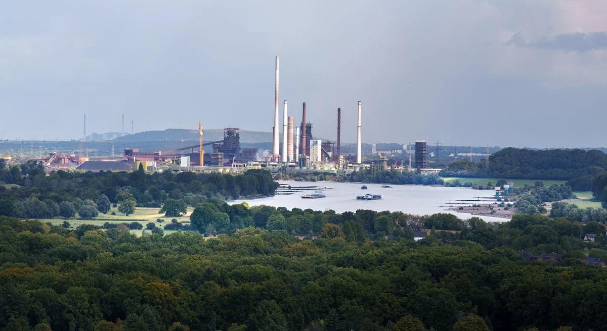 Industriekomplex am Fluss mit Schornsteinen